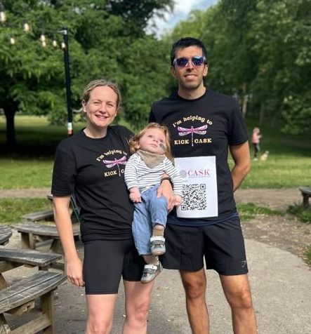 A photo of a mum and dad in running gear holding their sick baby boy
